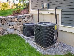 Residential installation of two outdoor air conditioning condenser units on concrete pads with line sets to the home